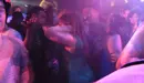 Varias personas bailan en una discoteca.