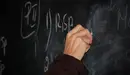 Un profesor escribe una ecuación en la pizarra de la clase de un colegio. ARCHIVO
