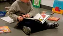 Un niño leyendo en la biblioteca infantil CIVICAN