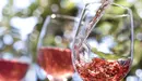 Una persona sirve varias copas de vino rosado durante una cata en una bodega ARCHIVO