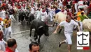 Corredores y toros de la ganadería de José Escolar a su paso por el tramo de Telefónica hacia el callejón, durante el segundo encierro de San Fermín en Pamplona EFE - Daniel Fernández