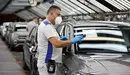 Un empleado de Volkswagen Navarra, con sus equipos de protección individual colocados, durante el desarrollo de su trabajo en el taller de Montaje. VW NAVARRA.