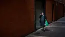 Una mujer con mascarilla y la compra en la mano camina por las calles del casco viejo durante la crisis del coronavirus en Pamplona. Miguel Osés