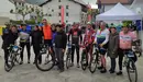 Miguel Induráin, de naranja a la izquierda, posando antes de la salida. Facebook La Peluso Cicloturista.