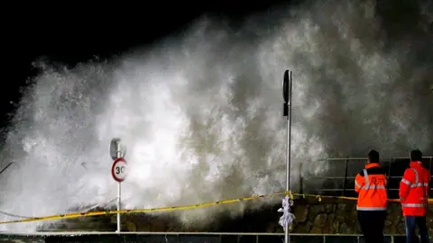 Una gran ola rompe contra el Paseo Nuevo de San Sebastián provocando que el agua inunde algunas calles de la Parte Vieja donostiarra. EFE.