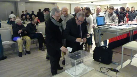 Los socios votan en una urna durante la asamblea.