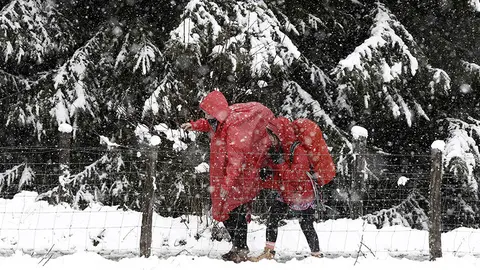 GRA249. ESPINAL (NAVARRA), 08/04/2016.- Dos peregrinos caminan por un monte cercano a la localidad navarra de Espinal en una jornada donde el descenso de la cota de nieve hasta los 700 metros ha sido la nota meteorológica del día. La cota sube hasta los 900 metros a lo largo del día asi como las temperaturas. EFE/Jesús Diges