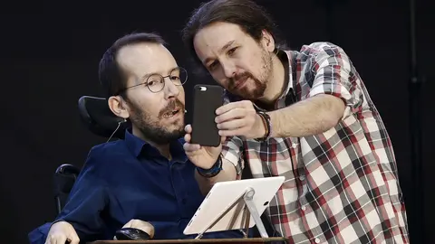 GRA678. PAMPLONA, 22/04/2016.- El secretario general de Podemos, Pablo Iglesias (d) y el secretario de Organización, Pablo Echenique, emiten a través de un movil un video en directo del acto abierto a toda la ciudadanía, dentro de la ruta "Atarse los cordones" que ha tenido lugar esta tarde en el Pabellon de la UPNA de Navarra. EFE/Jesús Diges