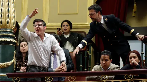 Un ujier llama la atención a una persona pide desde la tribuna de invitados libertad para Venezuela en el pleno del Congreso que se celebra hoy, en el que se debate una iniciativa presentada por el PP para la pronta liberación de los presos políticos en ese país. La sesión plenaria que se ha iniciado hoy será la última, ya que el próximo martes las Cortes se disolverán ante la convocatoria de nuevas elecciones.EFE/J.J. Guillén