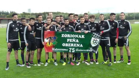 Osasuna posa con la pancarta de la Peña Oberena 75 años.