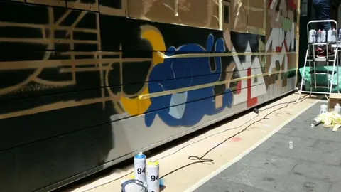 Trasnformación de la fachada de la tienda de Kukuxumusu en Pamplona con grafitis sanfermineros