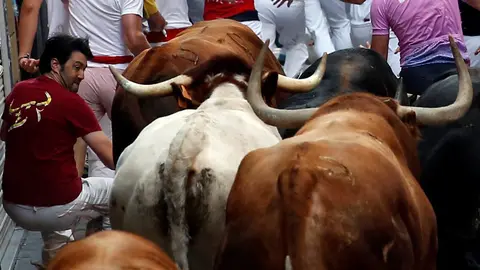 A runner falls next to Jandilla bulls during the fifth running of the bulls at the San Fermin festival in Pamplona, northern Spain, July 11, 2016. REUTERS/Susana VeraCODE: X01622