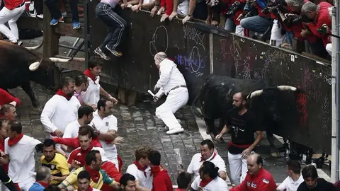 Dos toros de la ganadería de Núñez del Cuvillo entran en la curva de Mercaderes durante el séptimo encierro de los sanfermines 2016. EFE.Jesús Diges (1)