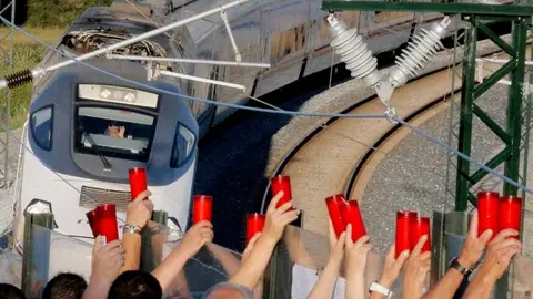 Homenaje  a las víctimas de Angrois, los asistentes levantan los cirios mientras el maquinista los saluda. EFE