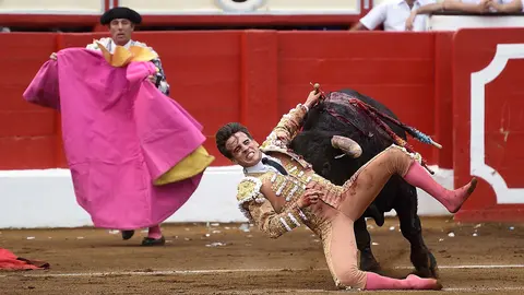 El diestro Gonzalo Caballero sufre una cogida en un momento de la corrida toros que se ha celebrado en la plaza de Cuatro Caminos de Santander. EFE/ Pedro Puente Hoyos