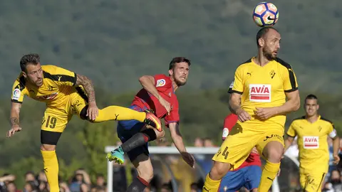 GRA152. ETXARRI ARANATZ (NAVARRA), 12/08/2016.- El defensa del Osasuna Oier Sanjurjo (d) lucha por un balón ante los defensas Iván Ramis (d) y Antonio Luna (i), del Eibar, durante el partido amistoso que han disputado ambos equipos hoy en el estadio San Donato de la localidad navarra de Etxarri Aranatz. EFE/Villar López