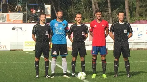 Imagen del trio arbitral y los dos capitanes en Boiro. Twitter.