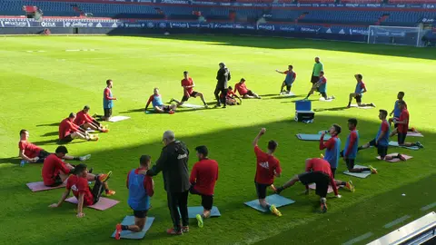 Los jugadores de Osasuna estiran en el estadio del Sadar.