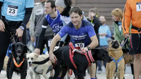 Varios atletas y sus perros se preparan para tomar la salida en el primer cross canino celebrado en el término urbano de Gorraiz y Olaz, en el Valle de Egüés (Navarra), en beneficio de la Asociación Navarra de Autismo (ANA). EFE/Villar López