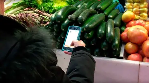 Una clienta paga su compra con el móvil en el Mercado de Santo Domigo de Pamplona. BOLETUS