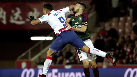 El delantero argentino del Granada Ezequiel Ponce (primer término) golpea al defensa del Osasuna Oier Sanjurjo durante el partido de la decimoctava jornada de Liga que disputan en el estadio Nuevo Los Cármenes. EFE/Pepe Torres
