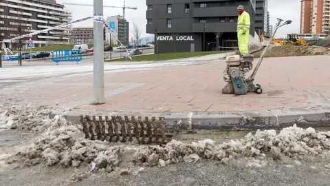 Operarios del Ayuntamiento trabajan para limpiar la vía y arreglar la fuga que ha producido una gran placa de hielo en el cruce entre la Avda. Juan Pablo II y la calle Cataluña. IÑIGO ALZUGARAY