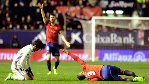 El jugador de Osasuna Tano (d) se lesiona ante Isco (i), del Real Madrid, durante el partido de Liga en Primera División disputado esta noche en el estadio de El Sadar. EFE