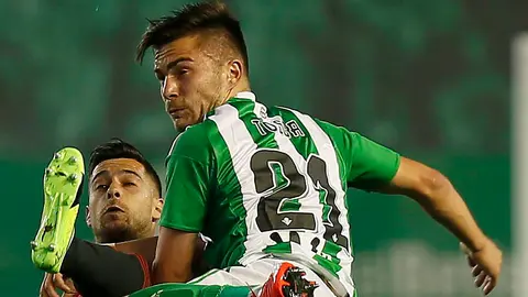 El delantero de Osasuna Sergio León (i) lucha el balón con el defensa rumano Alin Tosca, del Real Betis, en el estadio Benito Villamarín, en Sevilla. EFE/José Manuel Vidal.