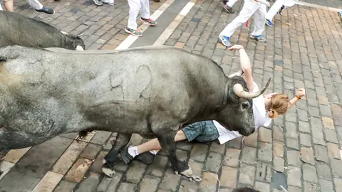 'Sentido', de la ganadería de José Escolar engancha con el asta a un joven en el de Pamplona en el segundo encierro JAVIER MARTÍNEZ 9