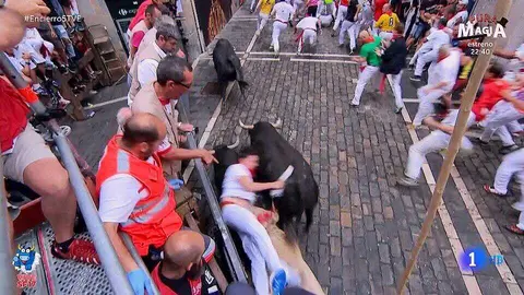 Un mozo cae entre los toros en la curva de Mercaderes con los toros de Jandilla en el quinto encierro