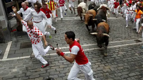 GRA028. PAMPLONA, 13/07/2017.- Los toros de la ganadería gaditada de Núñez del Cuvillo a su paso por la curva de Mercaderes durante el séptimo encierro de los San Fermines 2017, en el que las reses han protagonizado una rápida carrera de dos minutos y diez segundos hasta la arena de la plaza, y en la que, hasta el momento, se han contabilizado dos heridos por asta y un contusionado. EFE/Javier Lizón