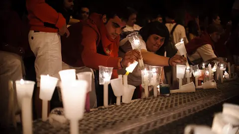 Los pamploneses dejan velas y pañuelos a las puertas de la parroquia de San Lorenzo, donde se encuentra la capilla de San Fermín. MIGUEL OSÉS