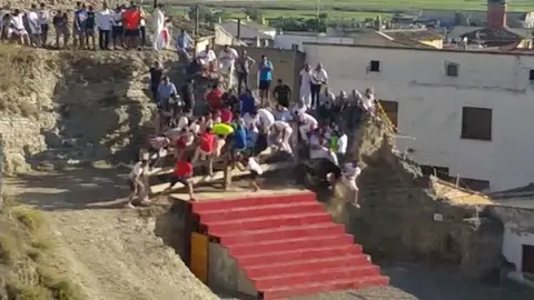 Una vaca embiste a un grupo de personas que se encontraban en el recorrido durante el primer encierro del estrecho en Arguedas CEDIDA