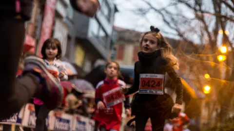 Niños y niñas desafían a la lluvia en la San Silvestre 2017 de Pamplona (14). IÑIGO ALZUGARAY