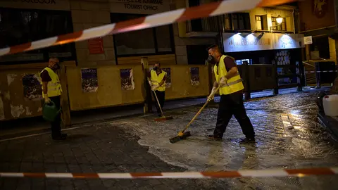 Operarios rocían liquido antideslizante en el recorrido del encierro de San Fermín. PABLO LASAOSA 07