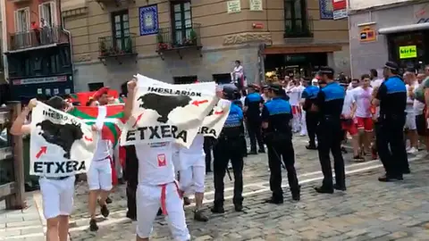 Un grupo de proetarras llega al Chupinazo de San Fermín 2018 con carteles e ikurriñas.