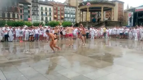Varios jóvenes patinan haciendo aquaplanning sobre el suelo mojado de la Plaza del Castillo tras la lluvia caída este 7 de julio, San Fermín CEDIDA