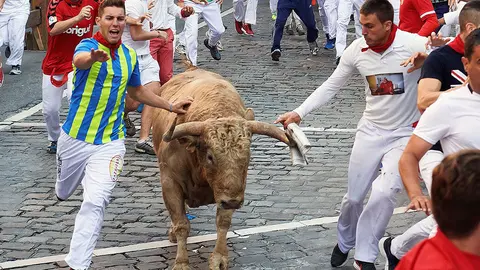 GRAF7819. PAMPLONA, 11/07/2018.- Un toro de la ganadería gaditana de Núñez del Cuvillo a su paso por el tramo de Telefónica durante el quinto encierro de los Sanfermines 2018 que ha resultado emocionante y vistoso con huecos entre los animales que han realizado el recorrido estirados, sin que al parecer ningún corredor haya resultado corneado. EFE/Daniel Fernández