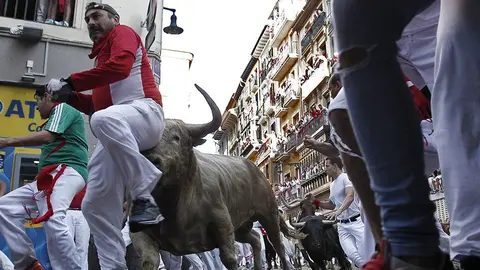 GRAF7831. PAMPLONA, 11/07/2018.- Los toros de la ganadería gaditana de Núñez del Cuvillo enfilan junto a mansos y corredores la curva de Mercaderes con la calle Estafeta durante el quinto encierro de los Sanfermines 2018 que ha resultado emocionante y vistoso con huecos entre los animales que han realizado el recorrido estirados, sin que al parecer ningún corredor haya resultado corneado. EFE/Jesús Diges