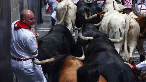 GRAF8618. PAMPLONA, 12/07/2018.- Los toros de la ganadería madrileña de Victoriano del Río Cortés hacen su entrada en la calle Estafeta tras pasar por la curva de Mercaderes durante el sexto encierro de los Sanfermines 2018 que ha sido veloz y limpio sin que los servicios asistenciales tengan constancia de heridos por asta. EFE/Rodrigo Jiménez