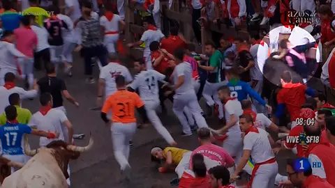 Momento en el que un toro golpea con el cuerno en el cuello a un  mozo en telefónica