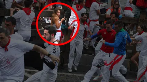 Una mujer hace fotos dentro del recorrido del encierro con toros de Victoriano del Rio en el tramo de Telefónica. IGNACIO RUBIO