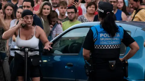 La hermana del detenido habla por teléfono mientras aguarda en el exterior del edificio. MIGUEL OSÉS