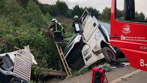 Los bomberos trabajan en Pueyo para rescatar el cuerpo sin vida del pasajero del camión accidentado. BOMBEROS DE NAVARRA (2)