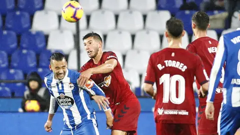 David García en acción ante Quique González en el partido Deportivo - Osasuna en Riazor. La Liga.
