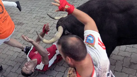 Un toro de Jandilla arrolla a un mozo en el cuarto encierro de San Fermín 2019 en el callejón. MIKEL CIAURRIZ (6)