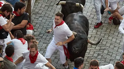 Los toros de la ganadería de Victoriano del Río, de Guadalix (Madrid), a su paso por el tramo final del callejón en dirección a la plaza, durante el quinto encierro de los Sanfermines 2019. EFE/J.P. Urdiroz