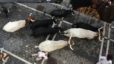 Los toros de la ganadería de Victoriano del Río, de Guadalix (Madrid), en el tramo de la calle Mercaderes, durante el quinto encierro de los Sanfermines 2019.- EFE/PEIO H.