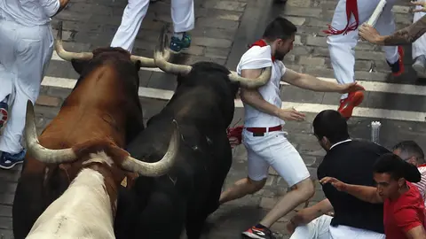 Los toros de la ganadería de La Palmosilla, de Tarifa (Cádiz), a su paso por la calle de Mercaderes, durante el séptimo encierro de los Sanfermines 2019.- EFE/Javier Lizón
