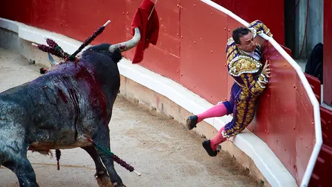Rafaelillo sufre una cogida en su segundo toro de la última corrida de los Sanfermines de 2019 con la ganadería de Miura. MIGUEL OSÉS